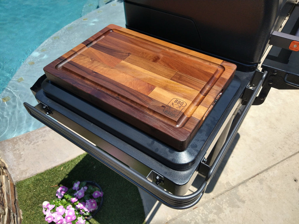 Wooden cutting board on a grill by a poolside